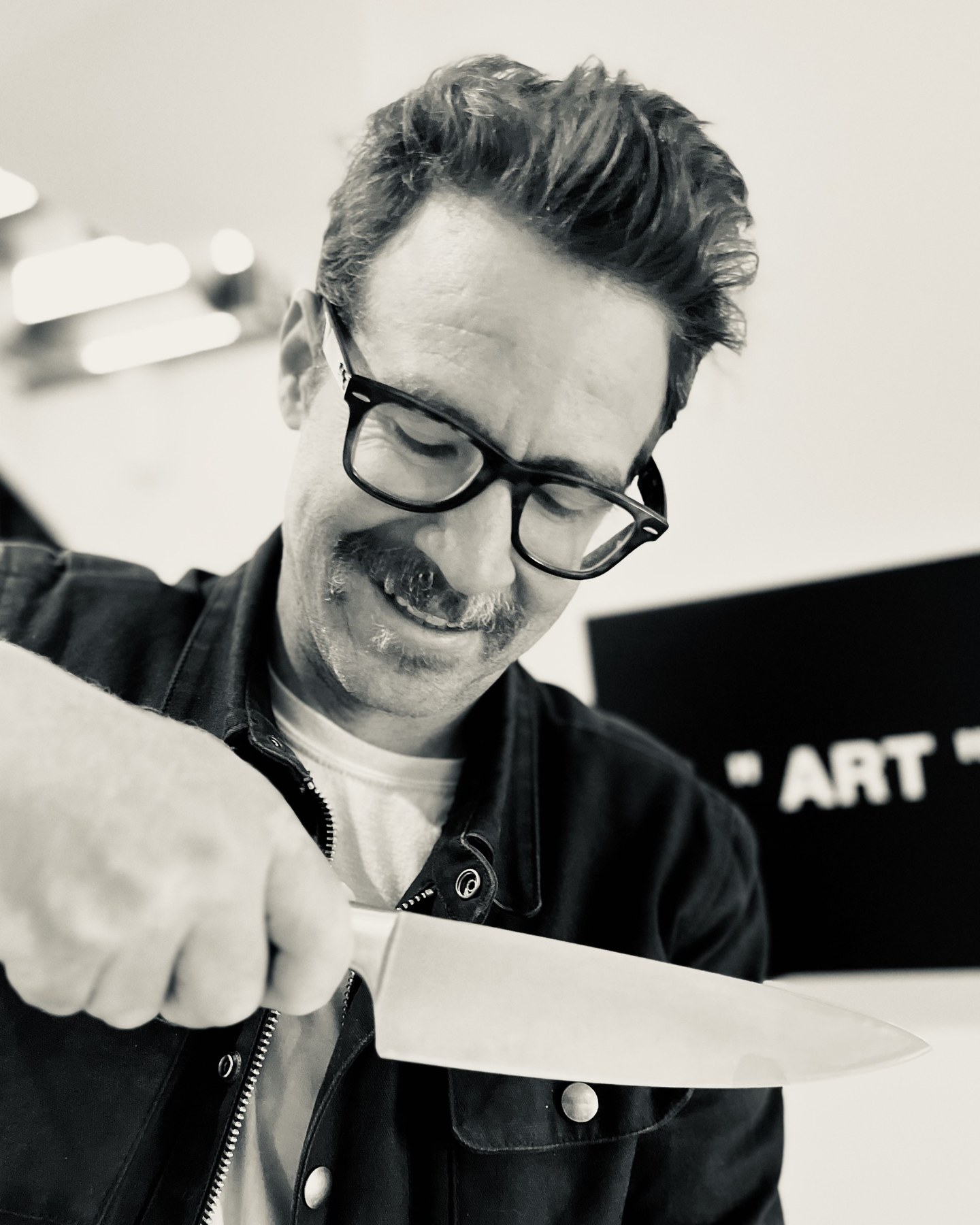 Black-and-white portrait of Cody preparing food in the kitchen