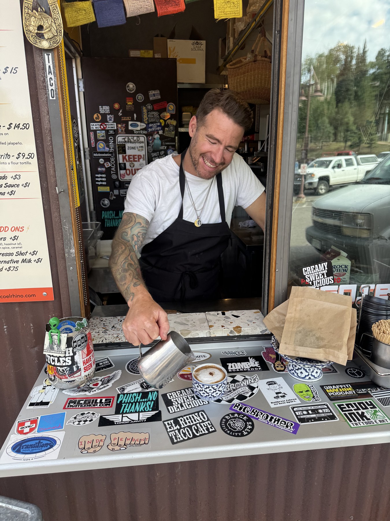 Cody working behind the sticker-covered counter at Taco El Rhino