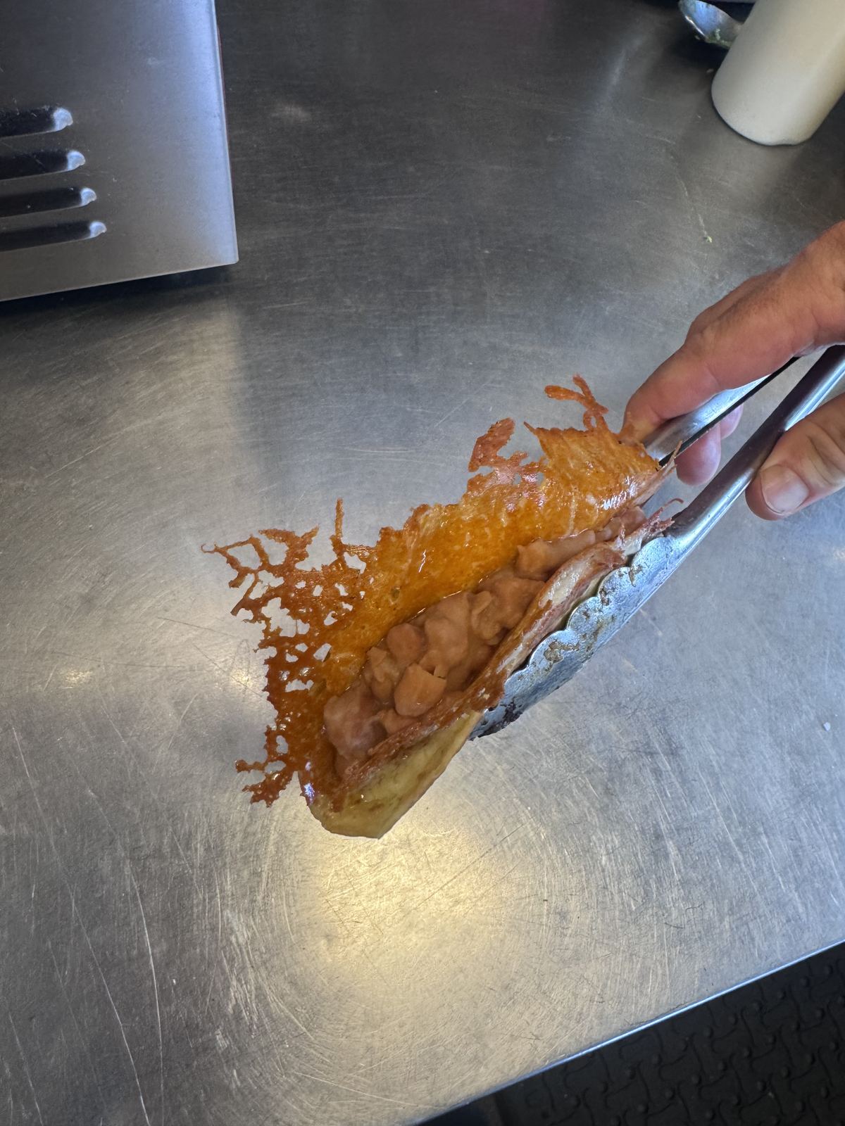 A crispy dorado taco being assembled on the kitchen counter