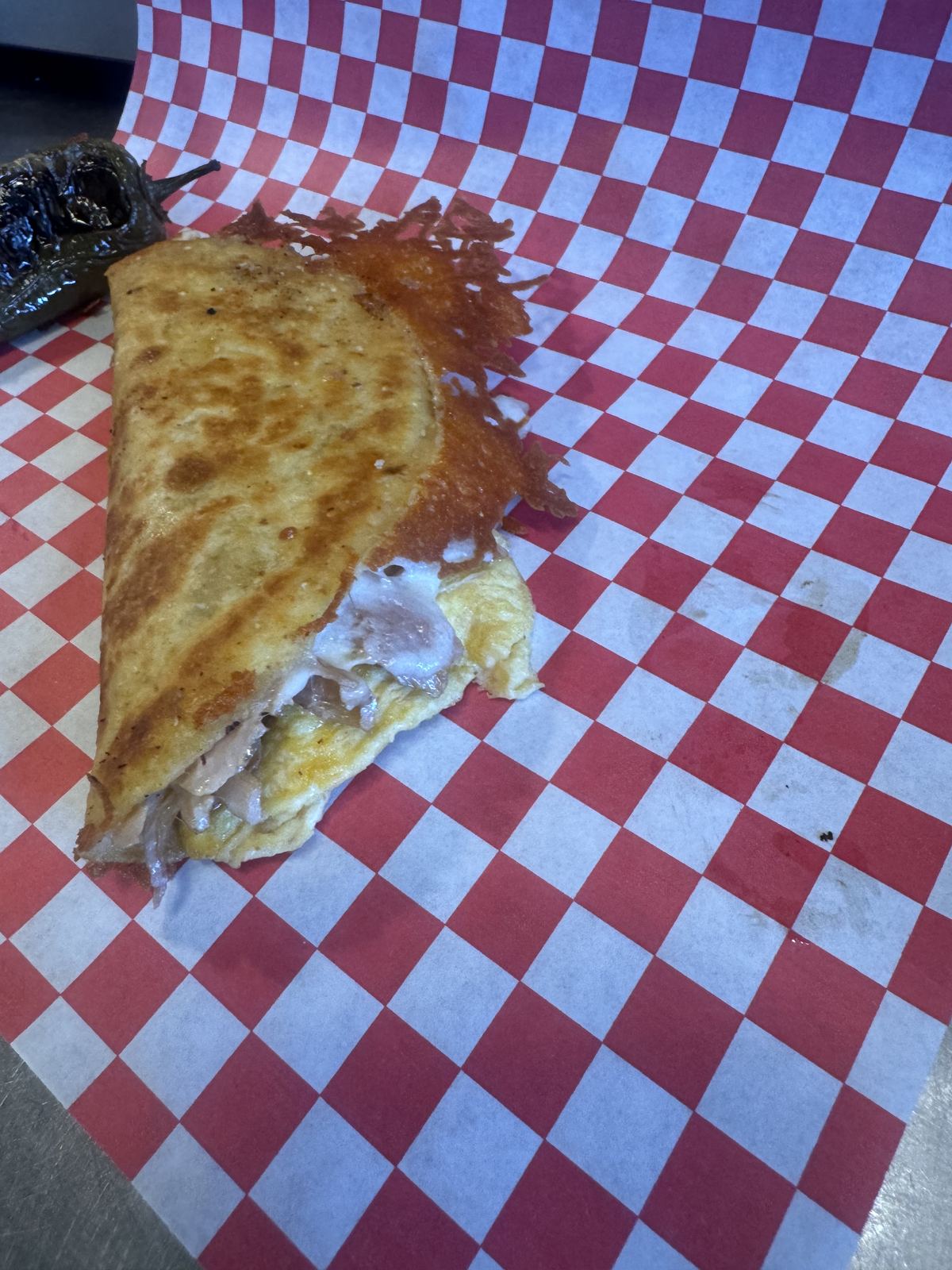 A toasted breakfast taco on red checkered paper