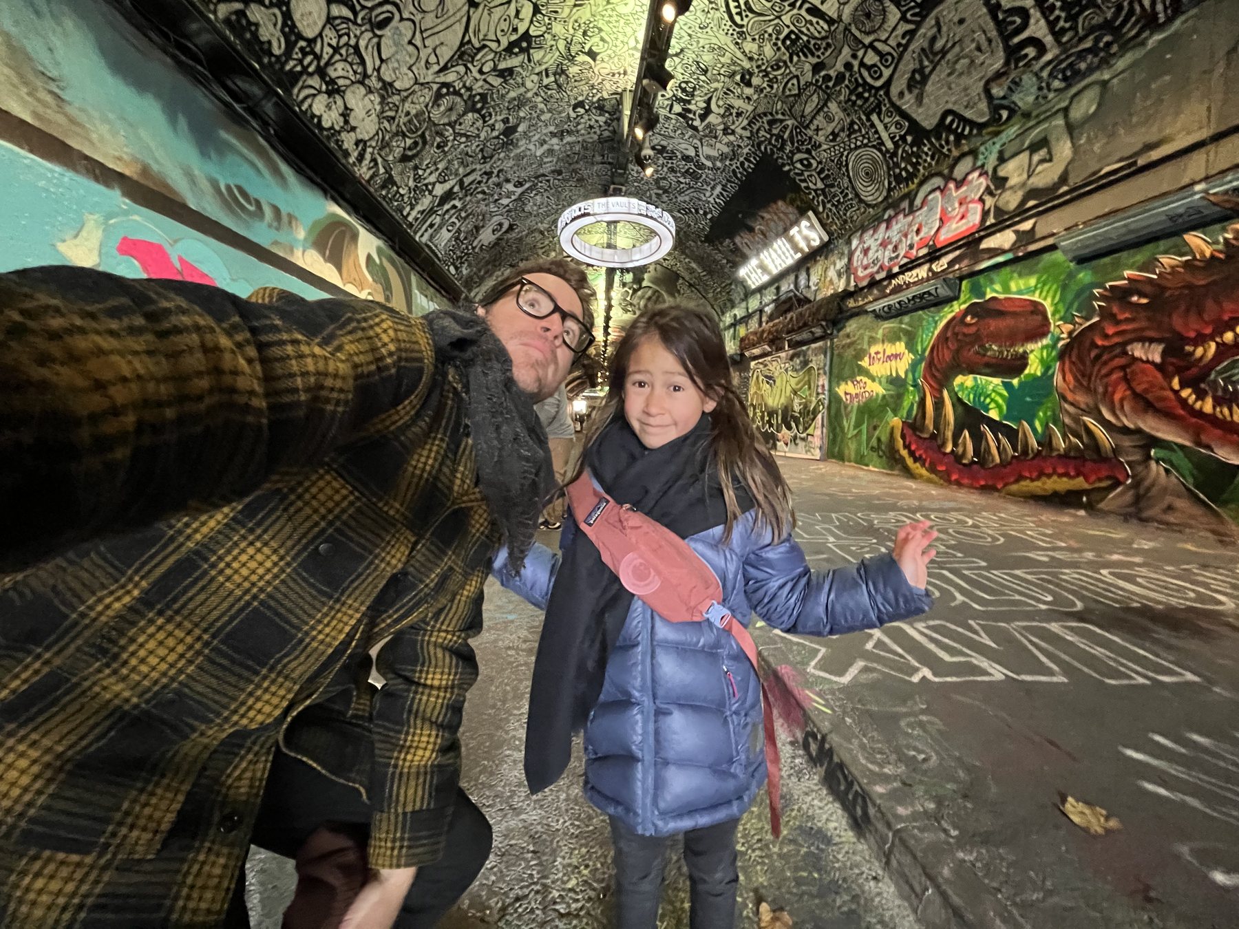 Cody and his daughter in a mural-covered city walkway